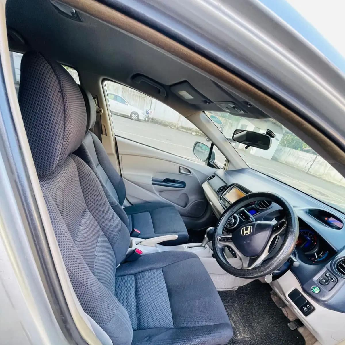 Dashboard, steering wheel and front seats inside a Honda Insight self-drive rental car from NOHA