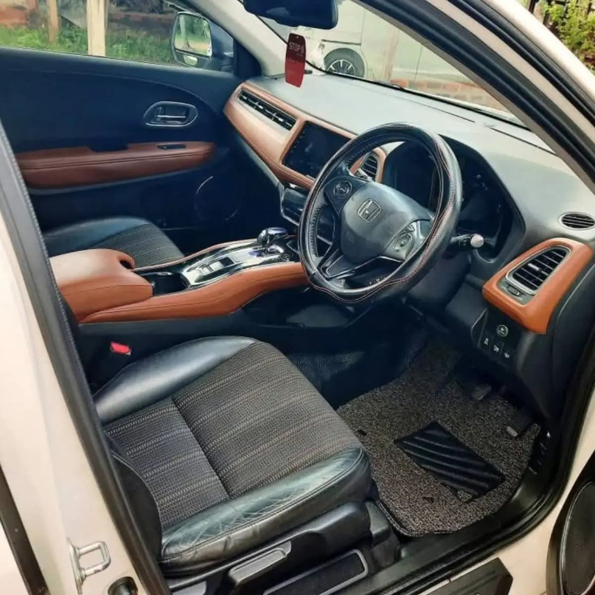 Dashboard, steering wheel and front seats inside a Honda Vezel self-drive rental car from NOHA