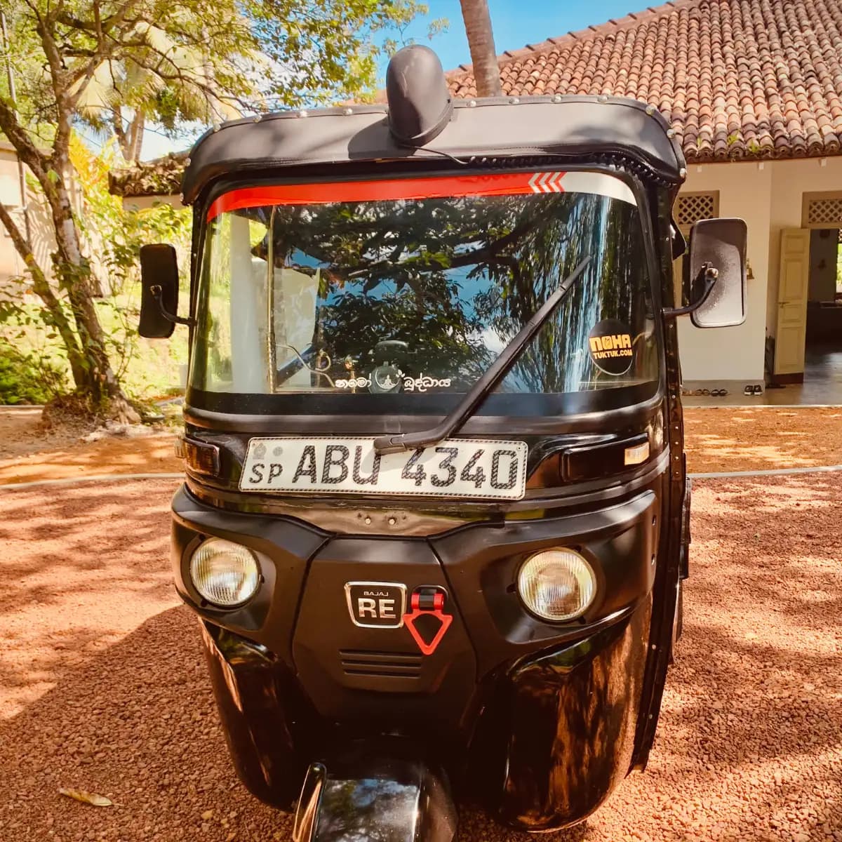 Front view of a red NOHA self-drive rental tuk tuk in Galle, Sri Lanka