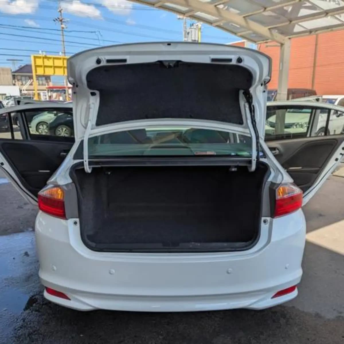 Open boot of a Honda Grace self-drive rental car, empty and ready for luggage