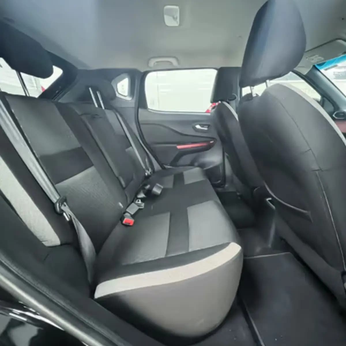 Rear seats inside a Nissan Magnite self-drive rental car from NOHA