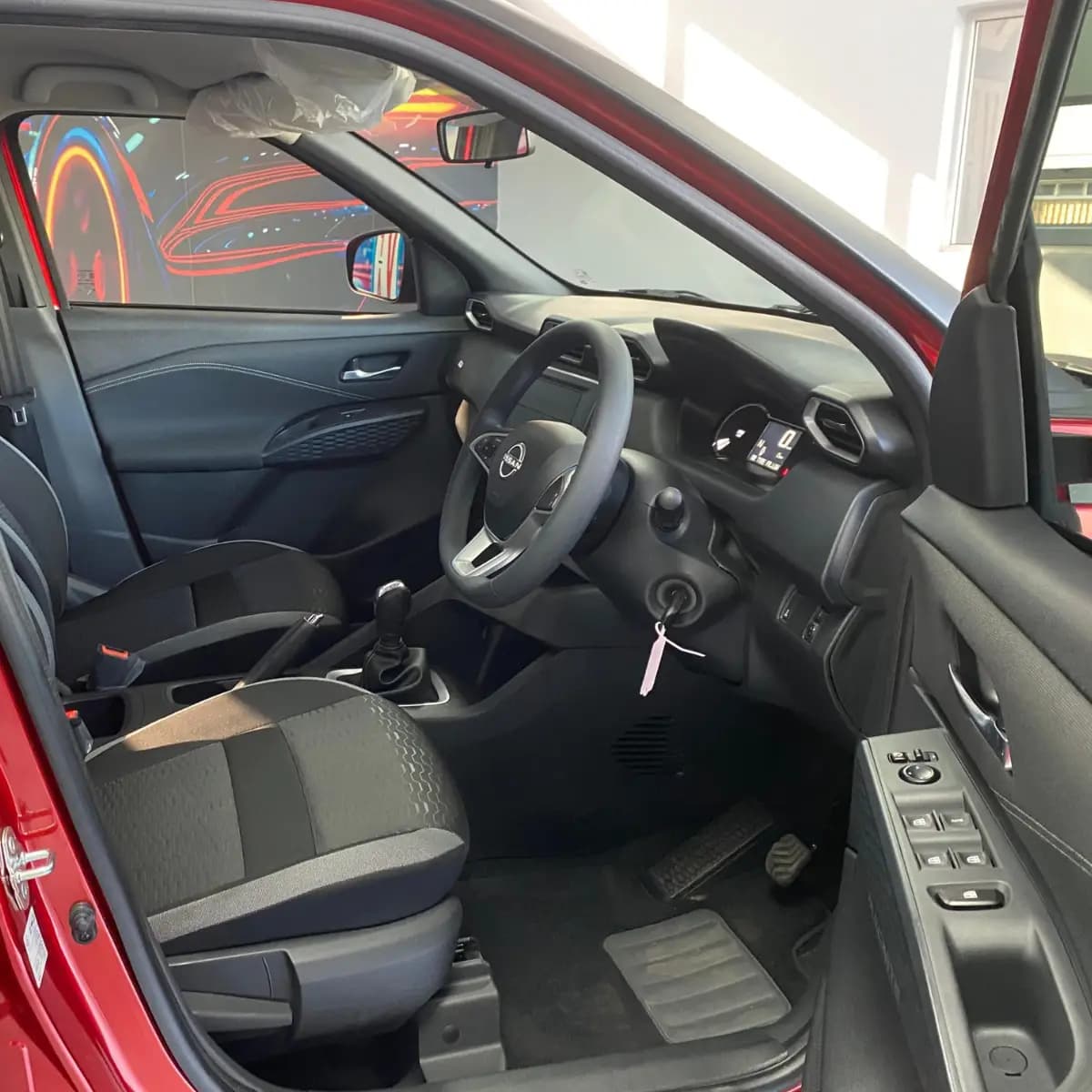 Dashboard, steering wheel and front seats inside a Nissan Magnite self-drive rental car from NOHA