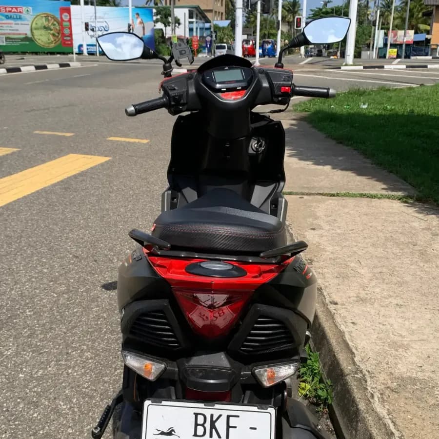 Rear of a NOHA rental scooter showing the external fuel cap