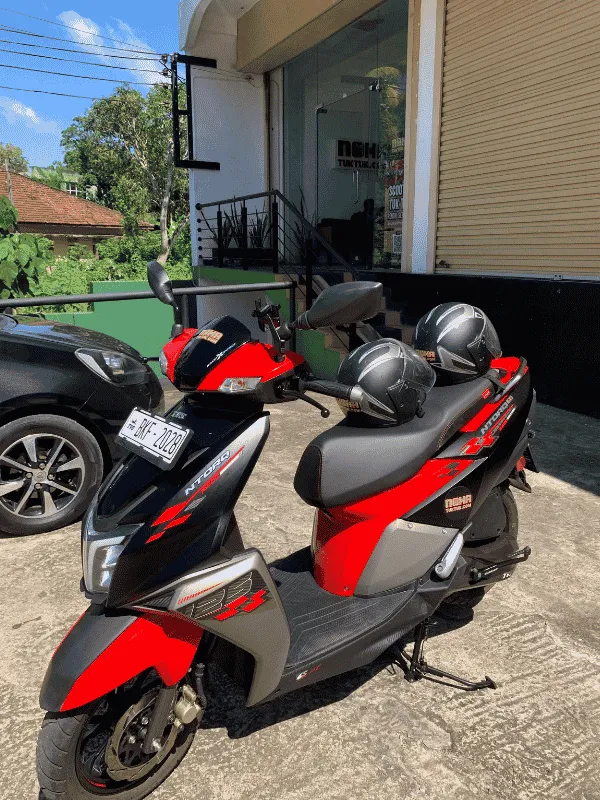 Rider wearing a helmet on an insured NOHA rental scooter